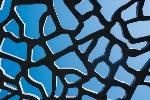 Perforated concrete on sky background abstract architectural pattern